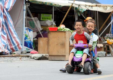 Photo taken on September 18, 2008 shows children play besides their temporary homes in Southwest China's Sichuan Province.
