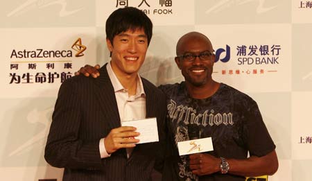 Chinese hurdler Liu Xiang (L) and U.S. hurdler Allen Johnson pose for media upon their arrival at a welcome reception for the 2008 Shanghai Golden Grand Prix track and field event in Shanghai, China, Sept. 19, 2008. [Xinhua]