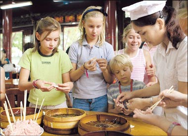 This undated photo shows foreigners learn how to make xiaolongbao, or steamed buns. [Shanghai Daily]