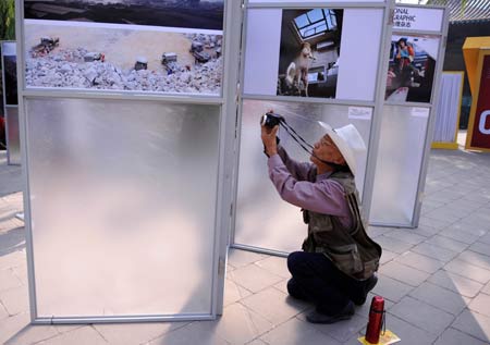 A visitor takes a picture of displayed visual works when roaming around at 2008 Pingyao International Photography Festival in Pingyao of north China's Shanxi Province Sept. 21, 2008. 