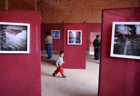 Visitors roam around to look at photos at 2008 Pingyao International Photography Festival in Pingyao of north China's Shanxi Province Sept. 21, 2008.