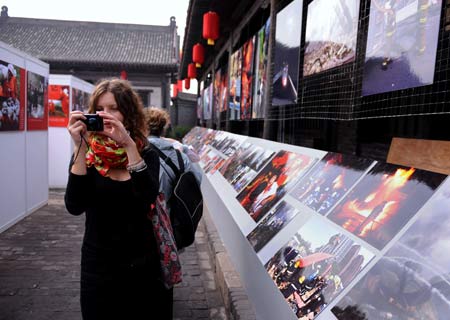 Visitors roam around to look at the photo works at 2008 Pingyao International Photography Festival in Pingyao of north China's Shanxi Province Sept. 21, 2008. [Xinhua Photo]