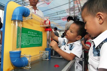 Children learn kownledge by watching a scientfic experiment eqiment during an science popularization activity in Fuzhou, southeast China&apos;s Fujian Province, Sept. 20, 2008, the National Science Popularization Day of China. [Xinhua]