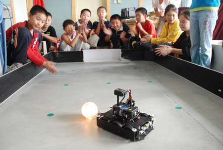 Pupils take part in a robot football match at Xingfujie Primary School in Weifang, east China&apos;s Shandong Province, Sept. 20, 2008m the National Science Popularization Day of China. [Xinhua]