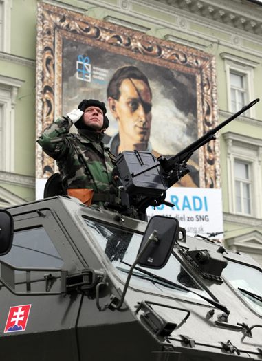 A soldier salutes from passing armoured vehicle during the Slovak military parade marking its 15th anniversary in Bratislava on September 21, 2008. [Xinhua]