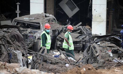 Pakistani rescue workers walk amid destroyed vehicles outside the devastated Marriott Hotel in Islamabad on September 21, 2008, following an overnight suicide bomb attack. Rescue teams entered the burning ruins of Islamabad&apos;s Marriott Hotel looking for bodies and survivors of a truck bombing which killed at least 60 people and left over 200 injured. [Xinhua]