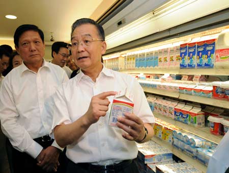 Chinese Premier Wen Jiabao (front) speaks while holds up a box of milk at Chang'an supermarket during an inspection on the milk products in Beijing on Sept. 21, 2008. [Xinhua Photo]