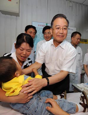 Chinese Premier Wen Jiabao calls on a child sickened by tainted milk powder at Beijing Children's Hospital in Beijing on Sept. 21, 2008. [Xinhua Photo]