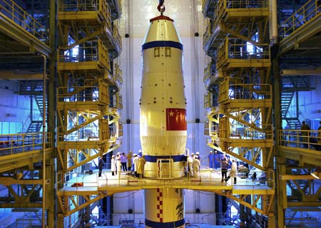 The undated photo shows technicians help the Shenzhou-7 manned spaceship to dock with the Long-March II-F rocket at an assembly plant. The spaceship has been finished docking with the rocket recently. (Xinhua/Qin Xian'an) 