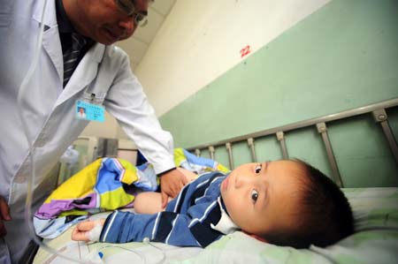 A doctor gives medical examination to a child with kidney diseases at the Gansu Maternity and Child Health Care Hospital in Lanzhou, capital of northwest China's Gansu Province, Sept. 18, 2008. [Xinhua] 