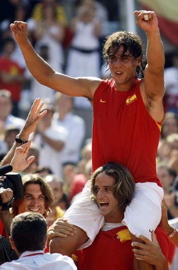 Spain's Rafael Nadal (top) is carried by team mate Feliciano Lopez as he celebrates victory over Andy Roddick of the U.S. after their singles tennis match for their Davis Cup semi-final match at Madrid's Las Ventas bullring September 21, 2008.
