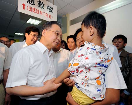 Chinese Premier Wen Jiabao (L, front) calls on a child sickened by tainted milk powder at Beijing Children's Hospital in Beijing on Sept. 21, 2008. 