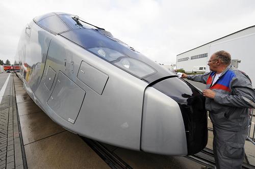 A worker cleans the front carriage of Alstom's new AGV high speed train at the Innotrans 'International Trade Fair for Transport Technology - Innovative Components, Vehicles, Systems' in Berlin on September 22, 2008. The fair takes place from September 23 to 26 and some 1600 exhibitors of 40 countries present products of the transport industry. [Xinhua]