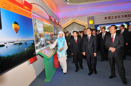 He Guoqiang (front 2nd R), member of the Standing Committee of the Political Bureau of the Communist Party of China (CPC) Central Committee and head of the Central Commission for Discipline Inspection, and a central government delegation, gestures when he visits an exhibition showing the achievement of northwest China's Ningxia Hui Autonomous Region in the past 50 years in Yinchuan, capital of the autonomous region, on Sept. 22, 2008. [Xinhua]