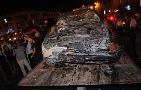 A damaged car is removed from the scene of an attack in Jerusalem September 22, 2008.