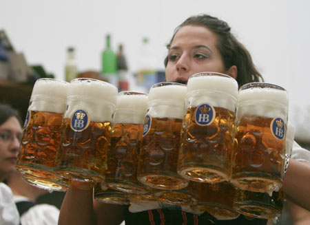 A waitress serves beers at Munich&apos;s Oktoberfest September 20, 2008. Millions of beer drinkers from around the world come to the Bavarian capital Munich for the world&apos;s bigest and most famous beer festival, the Oktoberfest. The 175th Oktoberfest lasts until October 5. [Xinhua]