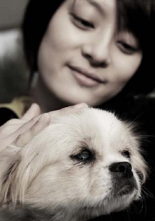 Chinese actress Sun Li is seen nurturing a dog in this photo to be displayed at a photographic exhibition in Beijing. Sun has written a book entitled 'Take Me Home,' sharing stories about stray animals. The book will be released this Friday to coincide with the opening of the exhibition.
