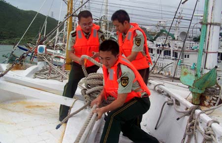 Frontier defense soldiers help fishermen reinforce boats in precaution against Hagupit, the 14th typhoon to affect China this year, in Zhangzhou City, southeast China's Fujian Province, Sept. 23, 2008. Local meteorological station issued a yellow signal for typhoon early Tuesday, warning the central and southern coastal area of Fujian against the outer rim of Hagupit. 