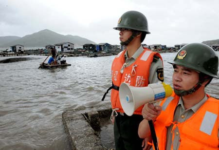 Policemen remind local fishermen to keep a lookout for the typhoon Hagupit in Pingtan County, southeast China&apos;s Fujian Province, Sept. 23, 2008. Fujian meteorological station issued a yellow alarm for typhoon Hagupit early Tuesday, warning the central and southern coastal areas of Fujian against the outer rim of Hagupit.