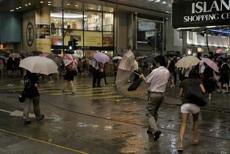 Pedestrians walk against heavy wind and rain on a street in Hong Kong, south China, Sept. 23, 2008. Hagupit, the 14th typhoon to affect China this year, is poised for landfall in the southern Guangdong Province on Wednesday, meteorological stations in Fujian and Guangdong provinces warned on Monday. [Zhou Lei/Xinhua] 