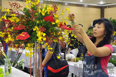 A contestant arranges flowers in this photo published on Monday, September 22, 2008. Over 100 flora artists took part in the flower-arranging competition held in Shunyi district of Beijing on Monday. The district will host the 7th China Flower Expo on September 26, 2009.