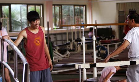 Chinese hurdler Liu Xiang (L) reacts in a training session in Shanghai, Sept. 23, 2008. This is Liu's first public training after he pulled out of the men's 110 meters hurdles because of injuries in Beijing Olympic Games on Aug. 18, 2008.