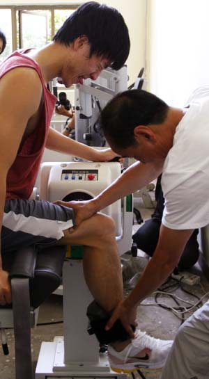 Chinese hurdler Liu Xiang (L) is helped in a training session in Shanghai, Sept. 23, 2008. This is Liu's first public training after he pulled out of the men's 110 meters hurdles because of injuries in Beijing Olympic Games on Aug. 18, 2008.