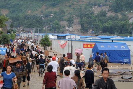 Local residents leave their temporary residence in Beichuan County, the epicenter of the May 12 devastating earthquake, after torrential rain lashed the region, triggering landslides and cave-ins, September 24, 2008.