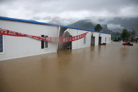 Local residents leave their temporary residence in Beichuan County, the epicenter of the May 12 devastating earthquake, after torrential rain lashed the region, triggering landslides and cave-ins, September 24, 2008.