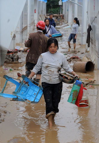 Local residents leave their temporary residence in Beichuan County, the epicenter of the May 12 devastating earthquake, after torrential rain lashed the region, triggering landslides and cave-ins, September 24, 2008.