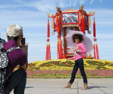 Visitors take photos in front of the decorative flower beds in front of the Tian'anmen Square before the National Day holiday in Beijing, September 25 2008. The 7-day-long holiday begins September 29. [CFP]