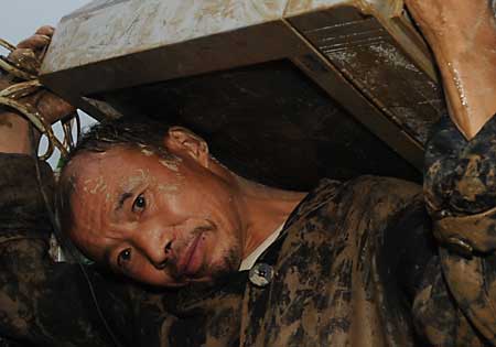  man with a TV set flees his home after a landslide caused by torrential rain in Leigu township, Beichuan county of southwest China&apos;s Sichuan Province on Sept. 24, 2008. 