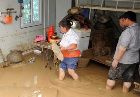 People collect their belongings after a landslide caused by torrential rain in Leigu township, Beichuan counry of southwest China's Sichuan Province on Sept. 24, 2008. [Xinhua Photo]
