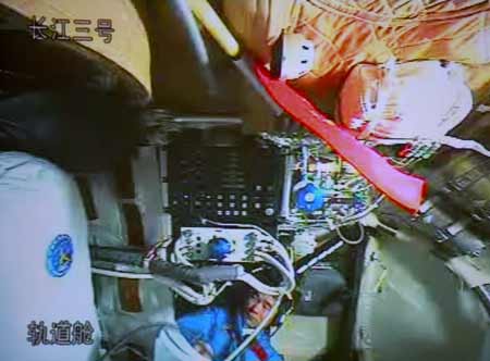 The video grab taken on Sept. 26, 2008 at the Beijing Space Command and Control Center in Beijing, China, shows Chinese astronaut Liu Boming unpacking and assembling the indigenous Feitian extra-vehicular activity (EVA) suit in Shenzhou-7. Astronauts aboard the Shenzhou-7 spacecraft, China&apos;s third manned spaceship, began to assemble the suit and test its obturation and functions at 10:20 a.m. Friday in preparation for the first spacewalk. [Xinhua]