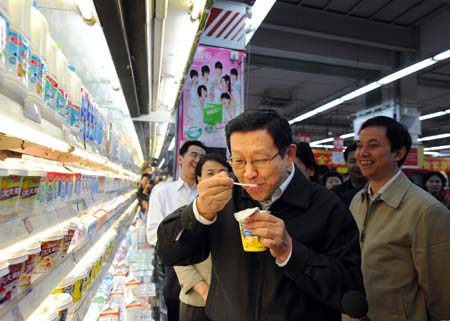 Chinese Minister of Commerce Chen Deming tastes a cup of yogurt at a supermarket in Beijing, Sept. 26, 2008. 