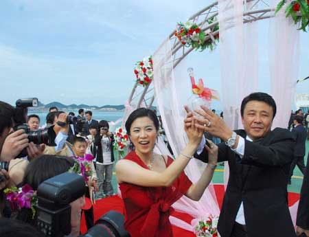 China's four-time Olympic table tennis gold medalist Wang Nan (L) ties the knot with her long-time partner Guo Bin aboard a yacht in Yantai, Shandong Province, Sept. 27, 2008. Wang's teammate Ma Lin, the reigning Olympic men's table tennis champion, and Japan's most popular table tennis star Ai Fukuhara were best man and maid of honor respectively.