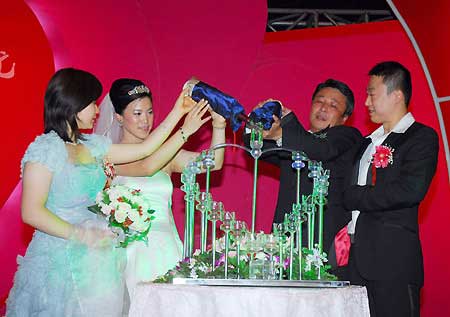 China's four-time Olympic table tennis gold medalist Wang Nan (2nd L) pours Champagne into glasses at her wedding with long-time partner Guo Bin onboard a luxury yacht in Yantai, Shandong Province, Sept. 27, 2008.