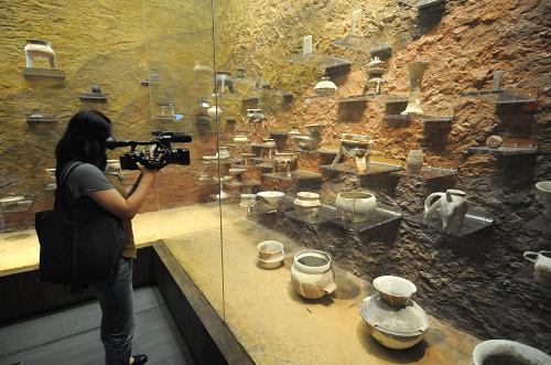 A reporter view pottery exhibits in the Liangzhu Culture Museum in Hangzhou, in Zhejiang province on Thursday, September 25, 2008. [Photo: Xinhua]