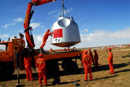 A search and rescue team hoists a replica of the returning module of the Shenzhou VII spacecraft onto a truck during a simulated drill on the Amugulang prairies in the middle of North China&apos;s Inner Mongolia Autonomous Region, September 25, 2008. [CFP]