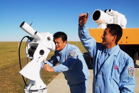 Search and rescue staff members monitor the flying trail of the returning module of the Shenzhou VII spacecraft during a simulated drill on the Amugulang prairies in the middle of North China&apos;s Inner Mongolia Autonomous Region, September 25, 2008. [CFP]