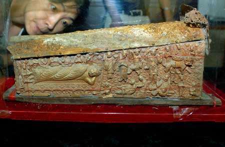 An archeological worker examines a 47cm×20cm×20cm gilt silver coffin excavated beneath a Buddihist pagoda in Yanzhou of east China's Shandong Province Sept. 25, 2008. 