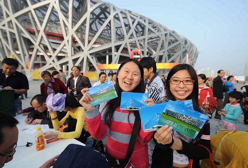 Two excited girls show up their post cards printed with the Bird's Nest and the Water Cube at an outdoor post office outside the Bird's Nest Stadium on Monday, September 29, 2008. [Xinhua] 