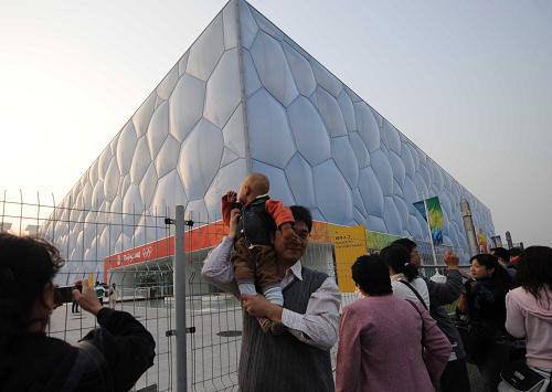 A father shoulders his kid for photos outside the Water Cube on Monday, September 29, 2008. [Xinhua]