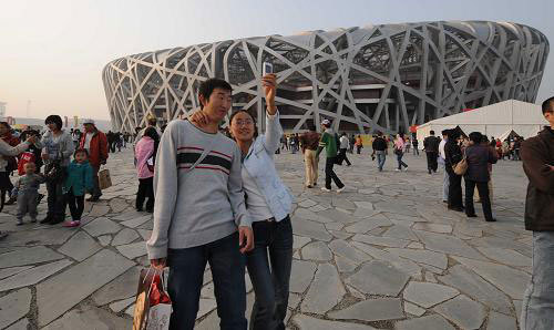 A couple snapshot themselves outside the Bird's Nest on Monday, September 29, 2008. [Xinhua]