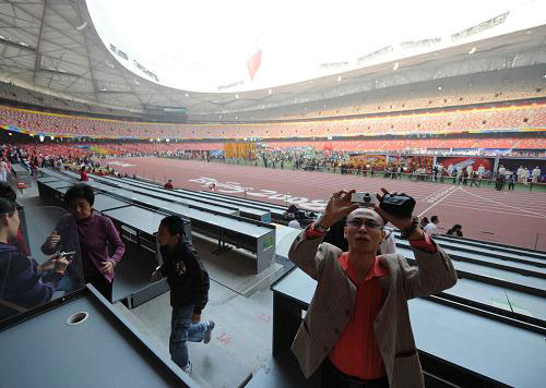 A tourist takes pictures at the press area in the Bird's Nest on Monday, September 29, 2008. [Photo: Xinhua]