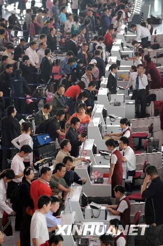 Passengers wait at a counter in the Beijing Capital International Airport on Monday, September 29, 2008. On the first day of the weeklong Chinese National Day holiday, the airport is expected to handle more than 200,000 passengers and 1,381 flights. [Xinhuanet]