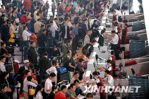 Passengers wait at a counter in the Beijing Capital International Airport on Monday, September 29, 2008. On the first day of the weeklong Chinese National Day holiday, the airport is expected to handle more than 200,000 passengers and 1,381 flights. [Xinhuanet] 