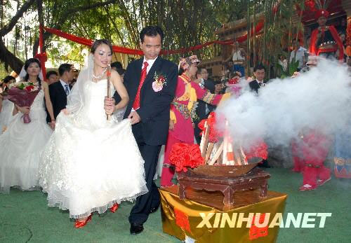 New couples experience Yi people's traditional wedding customs at a folk village in Shenzhen on Monday, the first day of the National Day holiday week. [Xinhua]