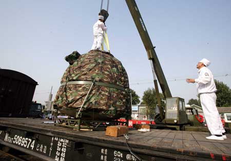The re-entry module of China's Shenzhou VII spacecraft is lifted onto a truck at Beijing's Changping railway station Sept. 30, 2008. The module was shipped to Beijing Tuesday afternoon, two days after its safe landing in northern China's Inner Mongolia. [Zha Chunming/Xinhua] 
