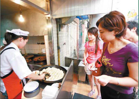 Customers queue for the pan-fried dumplings by Xiaoyang Shengjian, one of the most famous Shanghai snacks found on the old Wujiang Road. 